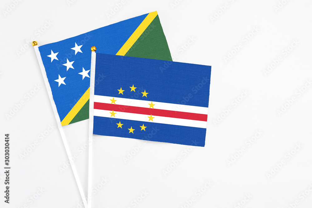 Cape Verde and Solomon Islands stick flags on white background. High quality fabric, miniature national flag. Peaceful global concept.White floor for copy space. Cape Verde and Solomon Islands stick flags on white background. High quality fabric, miniature national flag. Peaceful global concept.White floor for copy space.