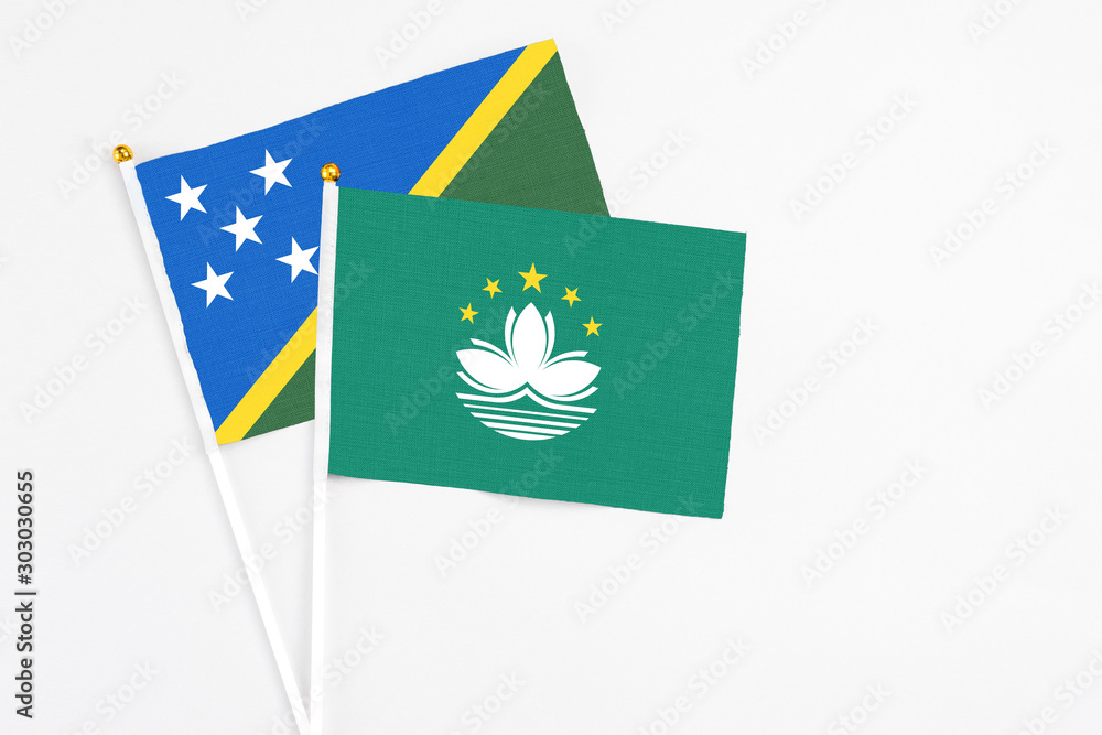 Macao and Solomon Islands stick flags on white background. High quality fabric, miniature national flag. Peaceful global concept.White floor for copy space.