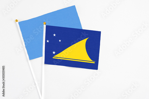 Tokelau and Somalia stick flags on white background. High quality fabric, miniature national flag. Peaceful global concept.White floor for copy space.