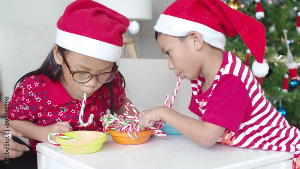 Children enjoy playing with candy cane on Christmas day Children enjoy playing with candy cane on Christmas day