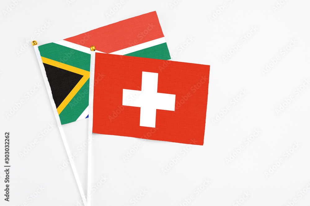 Switzerland and South Africa stick flags on white background. High quality fabric, miniature national flag. Peaceful global concept.White floor for copy space.