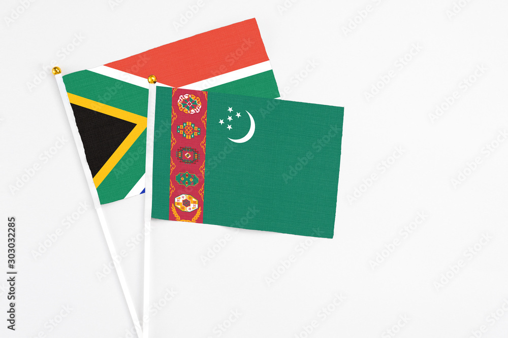 Turkmenistan and South Africa stick flags on white background. High quality fabric, miniature national flag. Peaceful global concept.White floor for copy space. Turkmenistan and South Africa stick flags on white background. High quality fabric, miniature national flag. Peaceful global concept.White floor for copy space.
