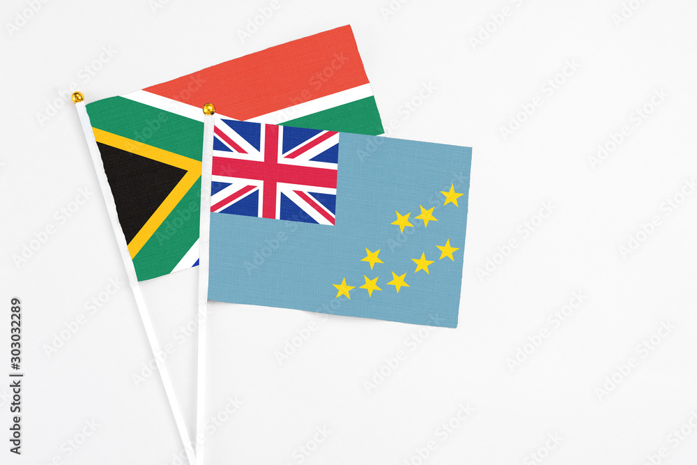 Fototapeta premium Tuvalu and South Africa stick flags on white background. High quality fabric, miniature national flag. Peaceful global concept.White floor for copy space.
