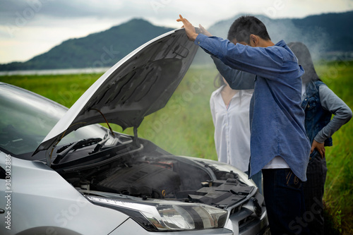 The man was shocked after opening the bonnet with smoke from the engine.car breakdown on the road. photo