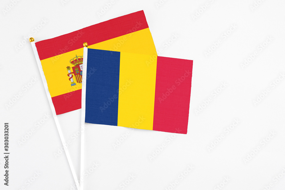 Fototapeta premium Chad and Spain stick flags on white background. High quality fabric, miniature national flag. Peaceful global concept.White floor for copy space.
