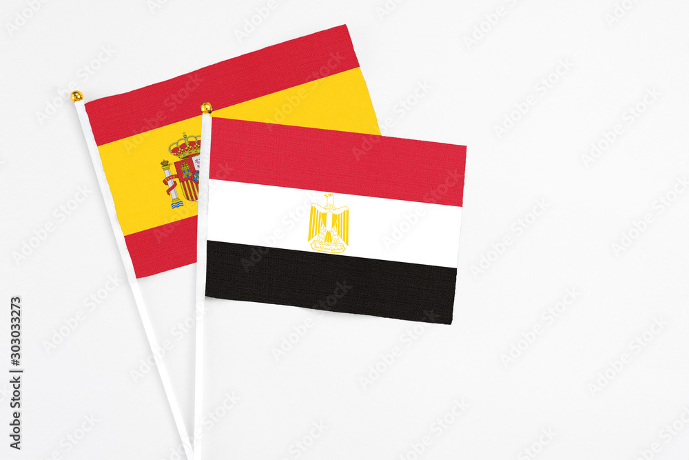 Egypt and Spain stick flags on white background. High quality fabric, miniature national flag. Peaceful global concept.White floor for copy space. Egypt and Spain stick flags on white background. High quality fabric, miniature national flag. Peaceful global concept.White floor for copy space.