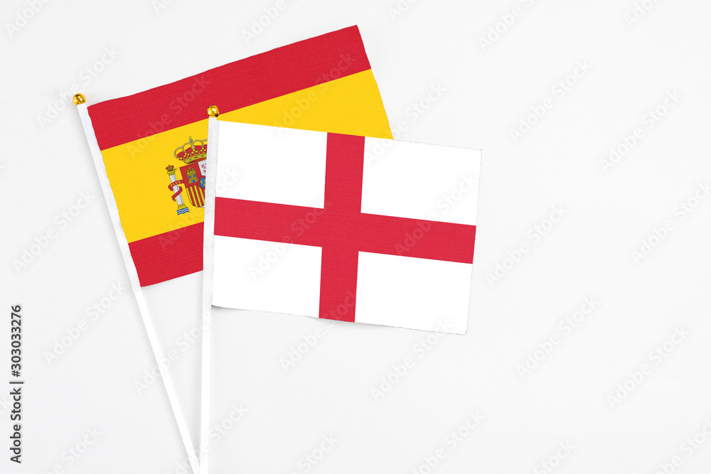 England and Spain stick flags on white background. High quality fabric, miniature national flag. Peaceful global concept.White floor for copy space.