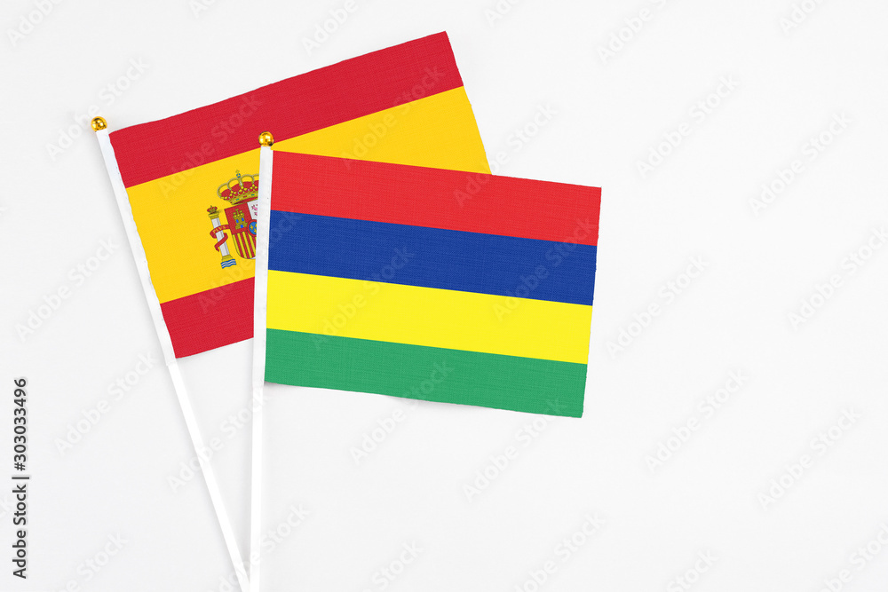 Mauritius and Spain stick flags on white background. High quality fabric, miniature national flag. Peaceful global concept.White floor for copy space. Mauritius and Spain stick flags on white background. High quality fabric, miniature national flag. Peaceful global concept.White floor for copy space.