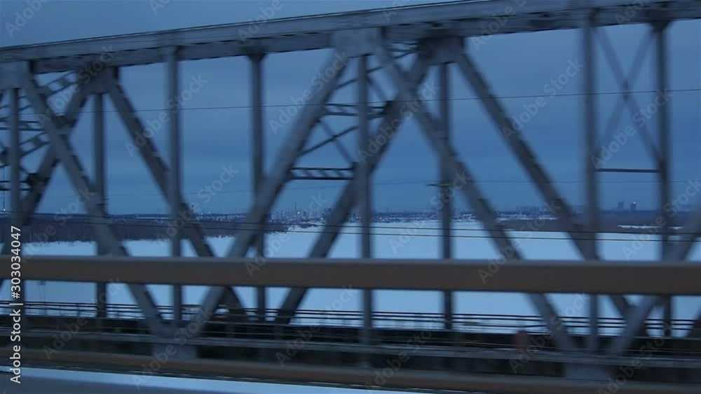 View of frozen Ob river through railway bridge and Surgut city in background, Russia View of frozen Ob river through railway bridge and Surgut city in background, Russia