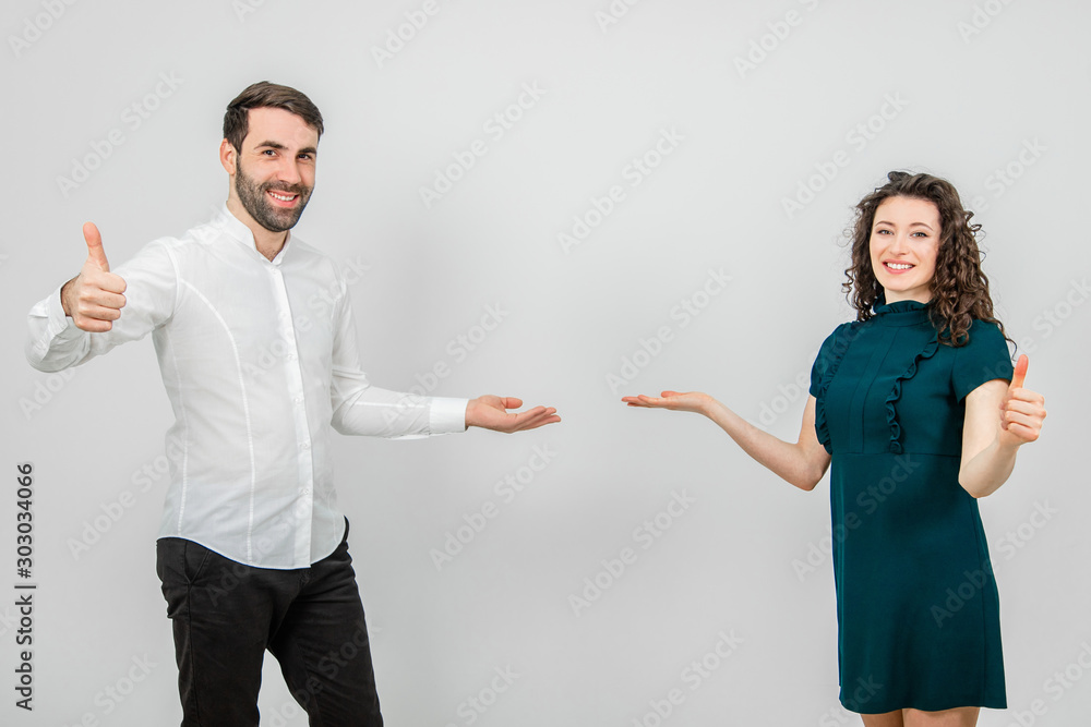 Confident and friendly coworkers showing thumbs up in recommendation and approval gesture, smiling delighted, presenting a good product. Confident and friendly coworkers showing thumbs up in recommendation and approval gesture, smiling delighted, presenting a good product.