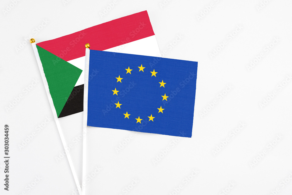 European Union and Sudan stick flags on white background. High quality fabric, miniature national flag. Peaceful global concept.White floor for copy space. European Union and Sudan stick flags on white background. High quality fabric, miniature national flag. Peaceful global concept.White floor for copy space.