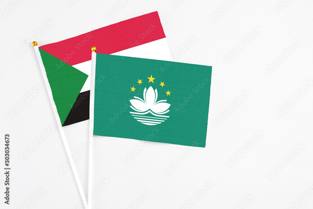 Macao and Sudan stick flags on white background. High quality fabric, miniature national flag. Peaceful global concept.White floor for copy space. Macao and Sudan stick flags on white background. High quality fabric, miniature national flag. Peaceful global concept.White floor for copy space.