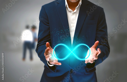 DevOps concept, an IT engineer holding the glowing devops symbol that illustrates the software development practices that automates the continuous development, build integration and deployment process