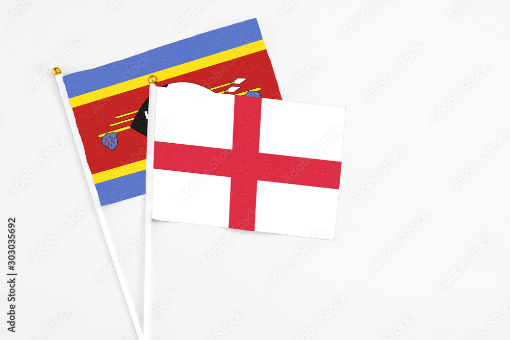 England and Swaziland stick flags on white background. High quality fabric, miniature national flag. Peaceful global concept.White floor for copy space.