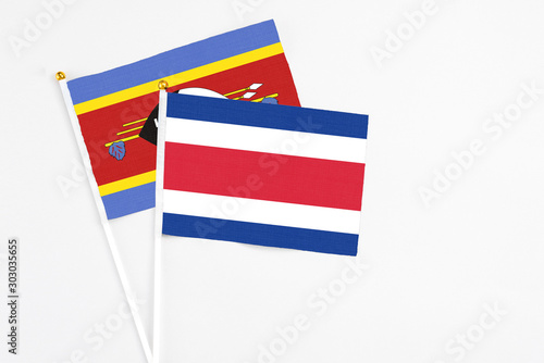 Free Download Costa Rica and Swaziland stick flags on white background. High quality fabric, miniature national flag. Peaceful global concept.White floor for copy space. - GFXLoad