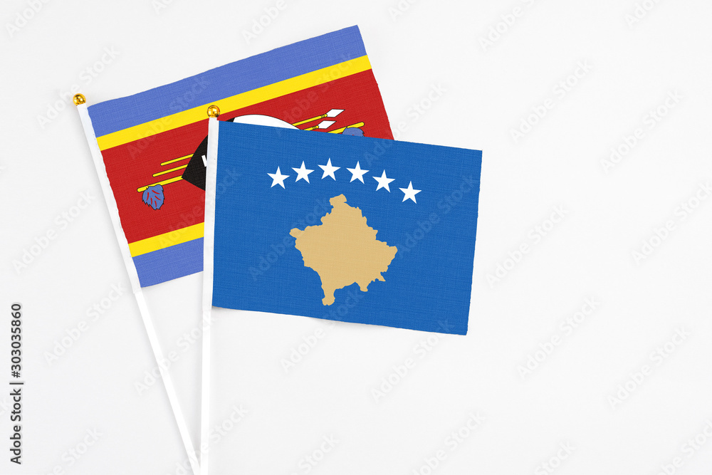 Kosovo and Swaziland stick flags on white background. High quality fabric, miniature national flag. Peaceful global concept.White floor for copy space. Kosovo and Swaziland stick flags on white background. High quality fabric, miniature national flag. Peaceful global concept.White floor for copy space.