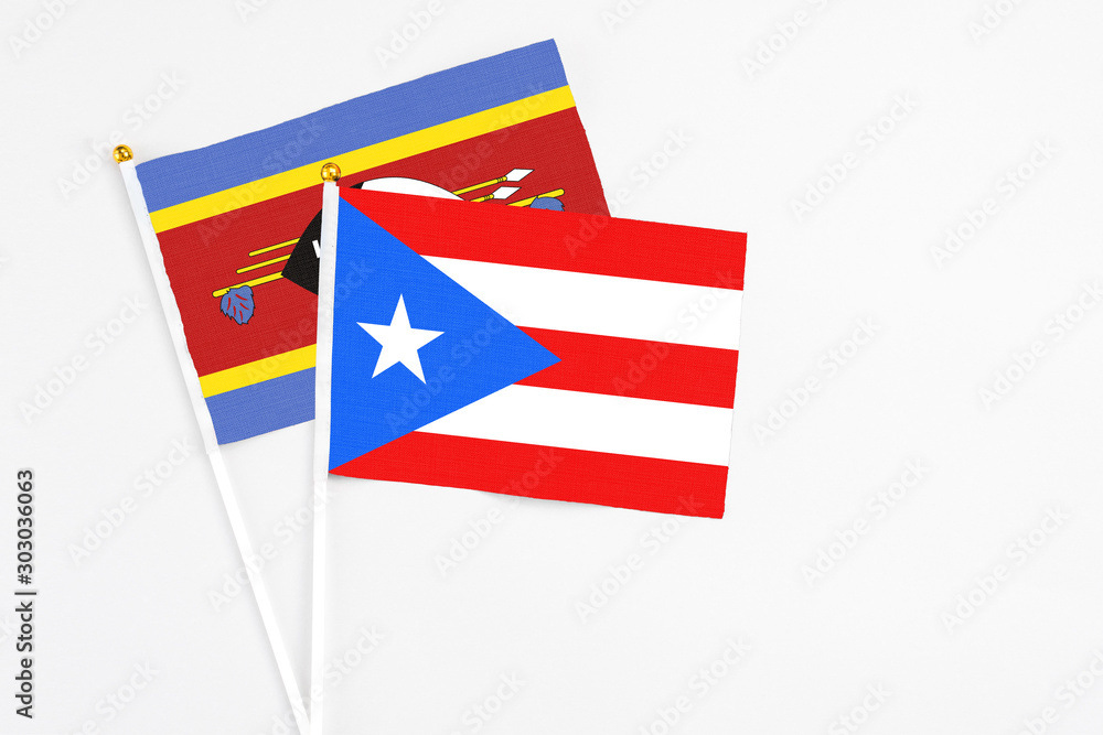 Puerto Rico and Swaziland stick flags on white background. High quality fabric, miniature national flag. Peaceful global concept.White floor for copy space. Puerto Rico and Swaziland stick flags on white background. High quality fabric, miniature national flag. Peaceful global concept.White floor for copy space.