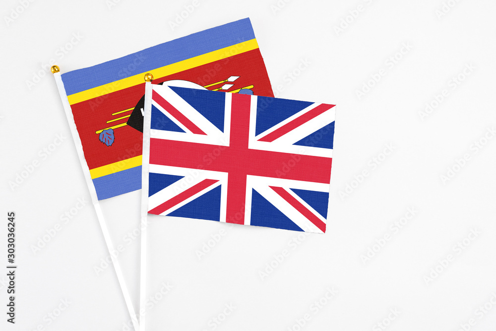 United Kingdom and Swaziland stick flags on white background. High quality fabric, miniature national flag. Peaceful global concept.White floor for copy space. United Kingdom and Swaziland stick flags on white background. High quality fabric, miniature national flag. Peaceful global concept.White floor for copy space.