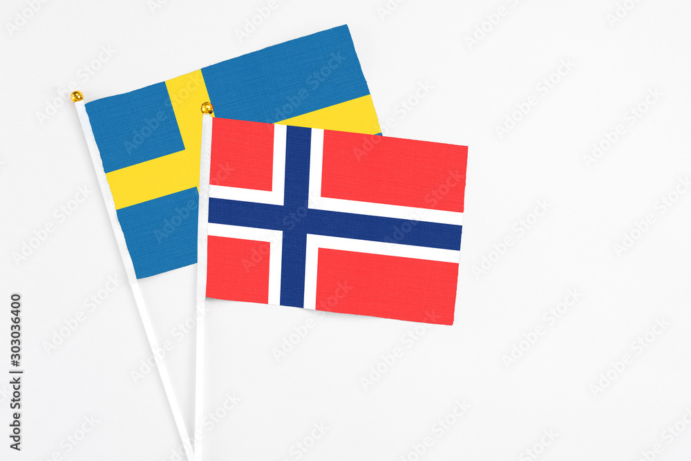 Bouvet Islands and Sweden stick flags on white background. High quality fabric, miniature national flag. Peaceful global concept.White floor for copy space.