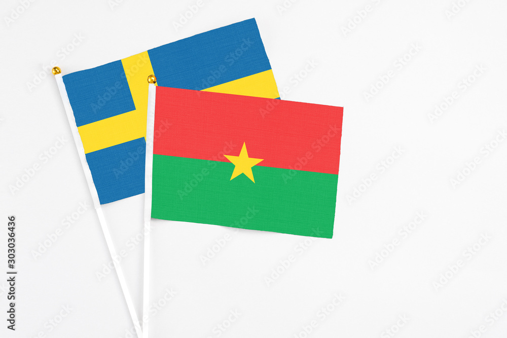 Burkina Faso and Sweden stick flags on white background. High quality fabric, miniature national flag. Peaceful global concept.White floor for copy space. Burkina Faso and Sweden stick flags on white background. High quality fabric, miniature national flag. Peaceful global concept.White floor for copy space.
