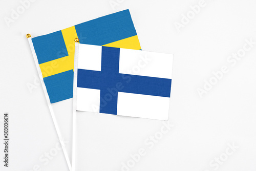 Finland and Sweden stick flags on white background. High quality fabric, miniature national flag. Peaceful global concept.White floor for copy space.