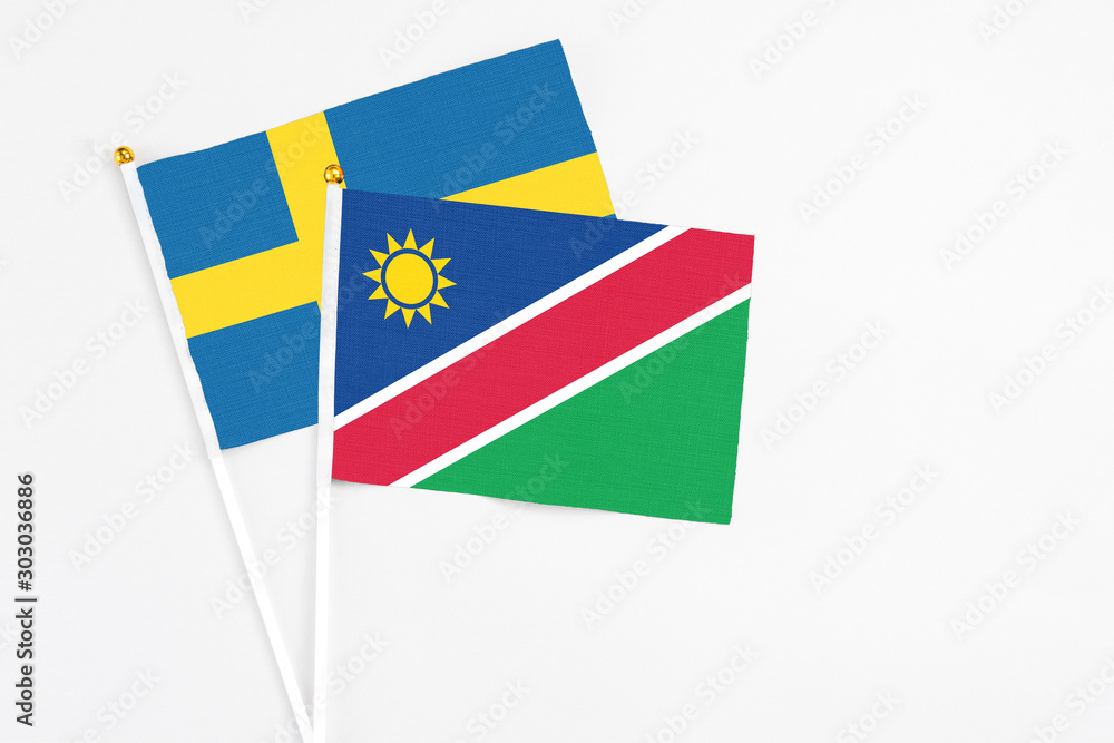 Namibia and Sweden stick flags on white background. High quality fabric, miniature national flag. Peaceful global concept.White floor for copy space. Namibia and Sweden stick flags on white background. High quality fabric, miniature national flag. Peaceful global concept.White floor for copy space.