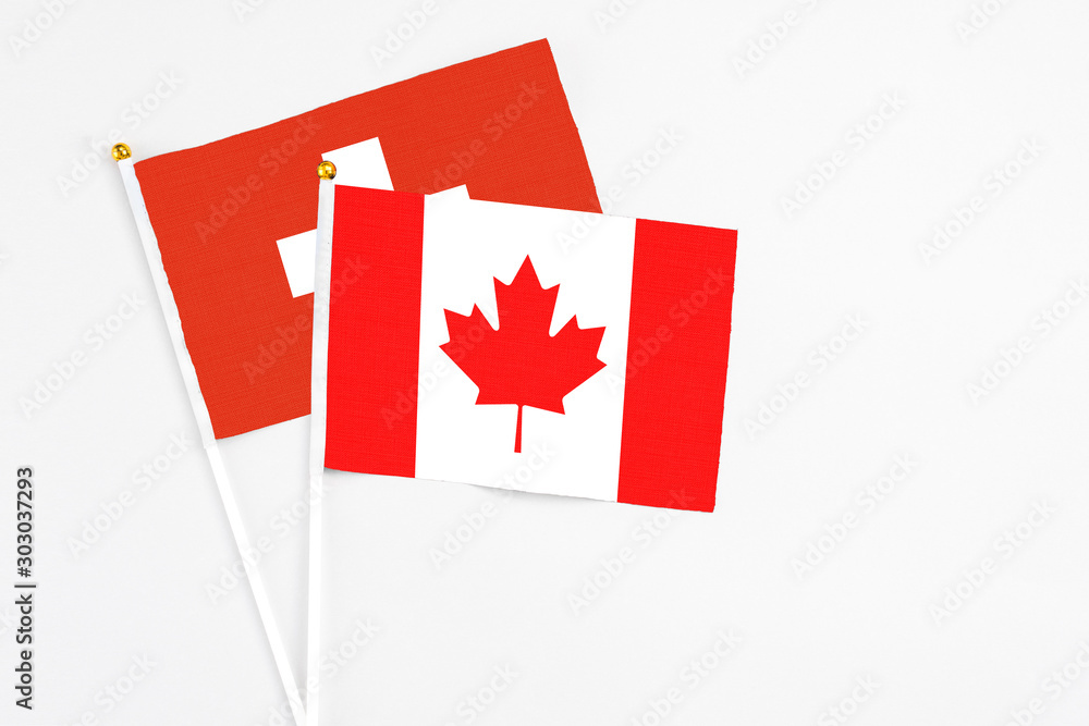 Canada and Switzerland stick flags on white background. High quality fabric, miniature national flag. Peaceful global concept.White floor for copy space. Canada and Switzerland stick flags on white background. High quality fabric, miniature national flag. Peaceful global concept.White floor for copy space.