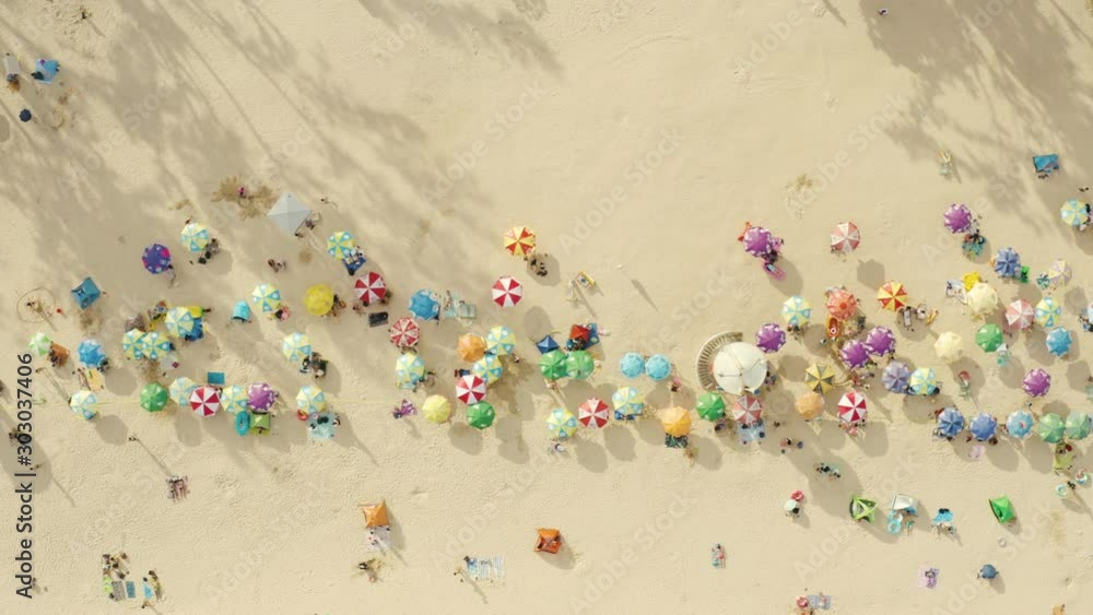 Aerial top view of beach with colorful umbrellas and people relaxing on a sunny day. Aerial top view of beach with colorful umbrellas and people relaxing on a sunny day.