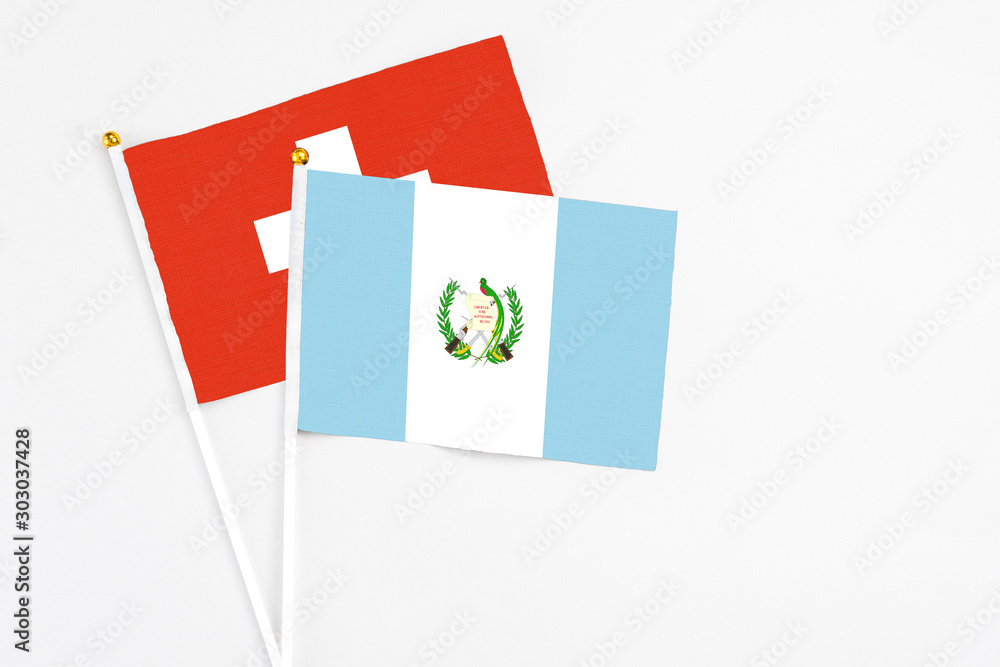Guatemala and Switzerland stick flags on white background. High quality fabric, miniature national flag. Peaceful global concept.White floor for copy space. Guatemala and Switzerland stick flags on white background. High quality fabric, miniature national flag. Peaceful global concept.White floor for copy space.