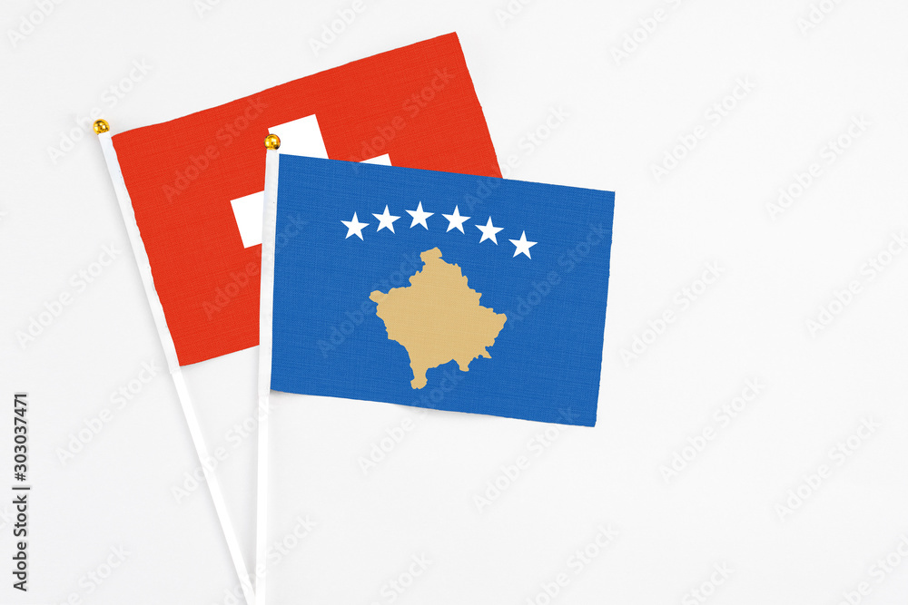 Kosovo and Switzerland stick flags on white background. High quality fabric, miniature national flag. Peaceful global concept.White floor for copy space. Kosovo and Switzerland stick flags on white background. High quality fabric, miniature national flag. Peaceful global concept.White floor for copy space.