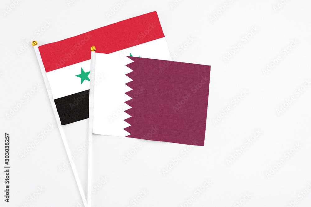 Qatar and Syria stick flags on white background. High quality fabric, miniature national flag. Peaceful global concept.White floor for copy space. Qatar and Syria stick flags on white background. High quality fabric, miniature national flag. Peaceful global concept.White floor for copy space.