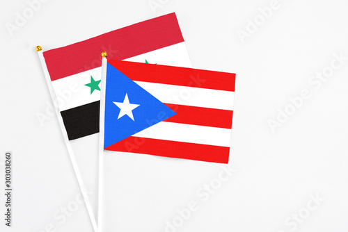 Puerto Rico and Syria stick flags on white background. High quality fabric  miniature national flag. Peaceful global concept.White floor for copy space.