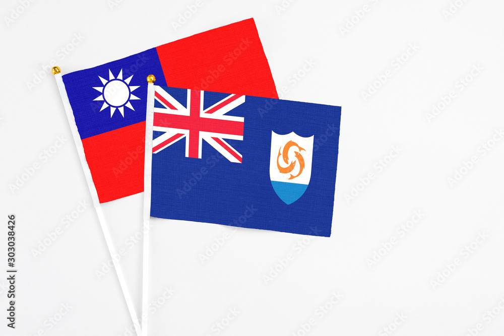 Fototapeta premium Anguilla and Taiwan stick flags on white background. High quality fabric, miniature national flag. Peaceful global concept.White floor for copy space.