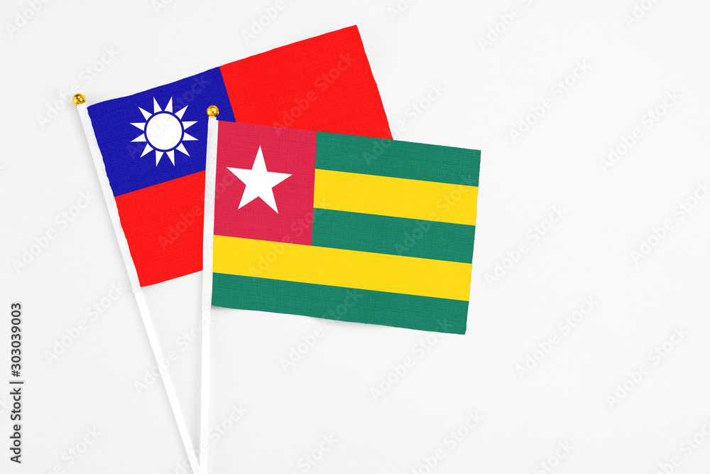 Togo and Taiwan stick flags on white background. High quality fabric, miniature national flag. Peaceful global concept.White floor for copy space. Togo and Taiwan stick flags on white background. High quality fabric, miniature national flag. Peaceful global concept.White floor for copy space.