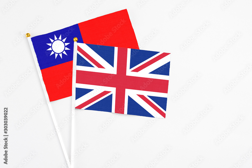 United Kingdom and Taiwan stick flags on white background. High quality fabric, miniature national flag. Peaceful global concept.White floor for copy space. United Kingdom and Taiwan stick flags on white background. High quality fabric, miniature national flag. Peaceful global concept.White floor for copy space.