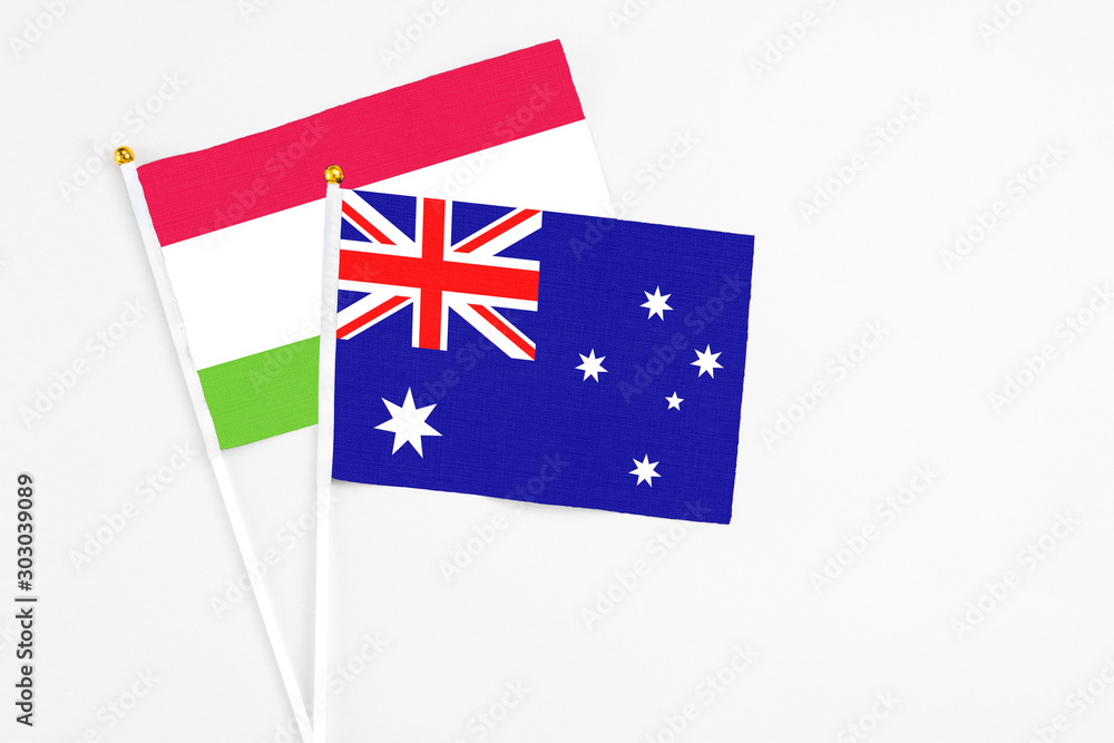 Fototapeta premium Australia and Tajikistan stick flags on white background. High quality fabric, miniature national flag. Peaceful global concept.White floor for copy space.