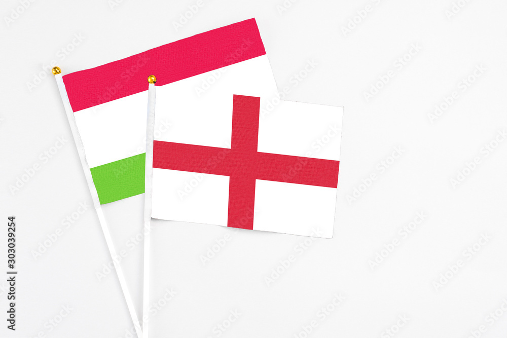 England and Tajikistan stick flags on white background. High quality fabric, miniature national flag. Peaceful global concept.White floor for copy space.