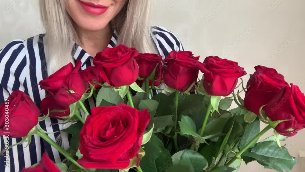 Beautiful woman blonde with a bouquet of red roses Beautiful woman blonde with a bouquet of red roses