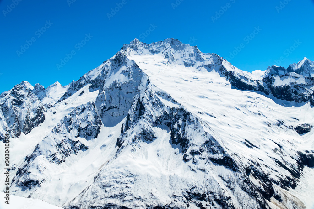 Caucasus mountains - The highest mountains in Russia. Snow mountains with blue sky background