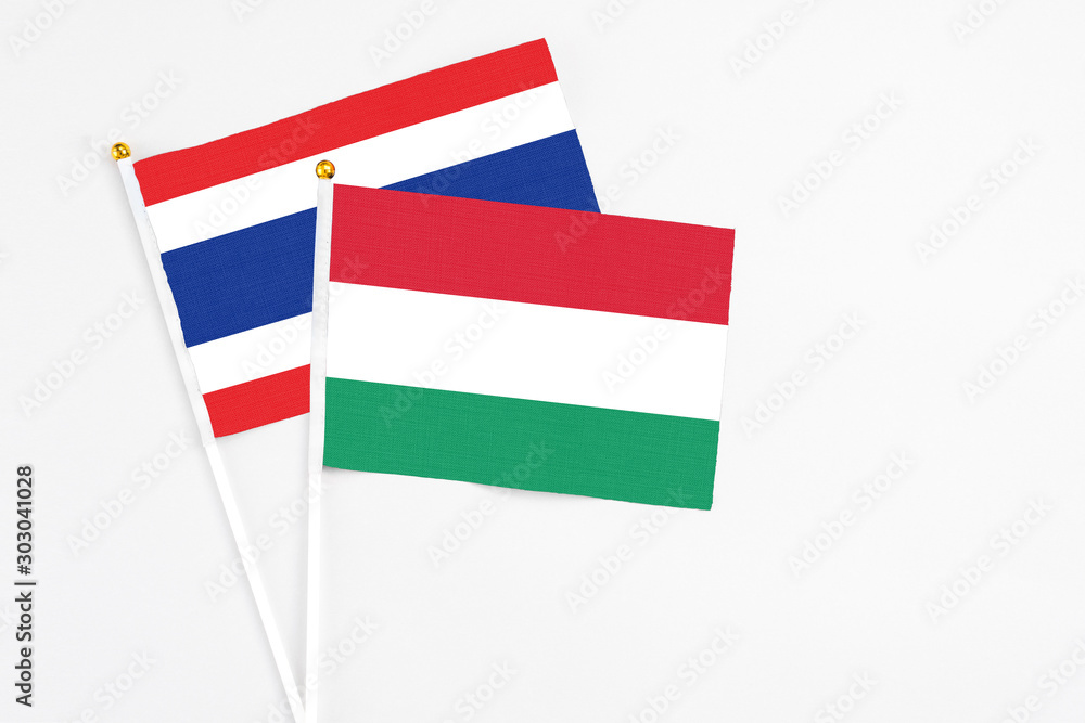 Hungary and Thailand stick flags on white background. High quality fabric, miniature national flag. Peaceful global concept.White floor for copy space. Hungary and Thailand stick flags on white background. High quality fabric, miniature national flag. Peaceful global concept.White floor for copy space.