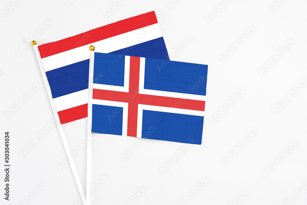 Iceland and Thailand stick flags on white background. High quality fabric, miniature national flag. Peaceful global concept.White floor for copy space.