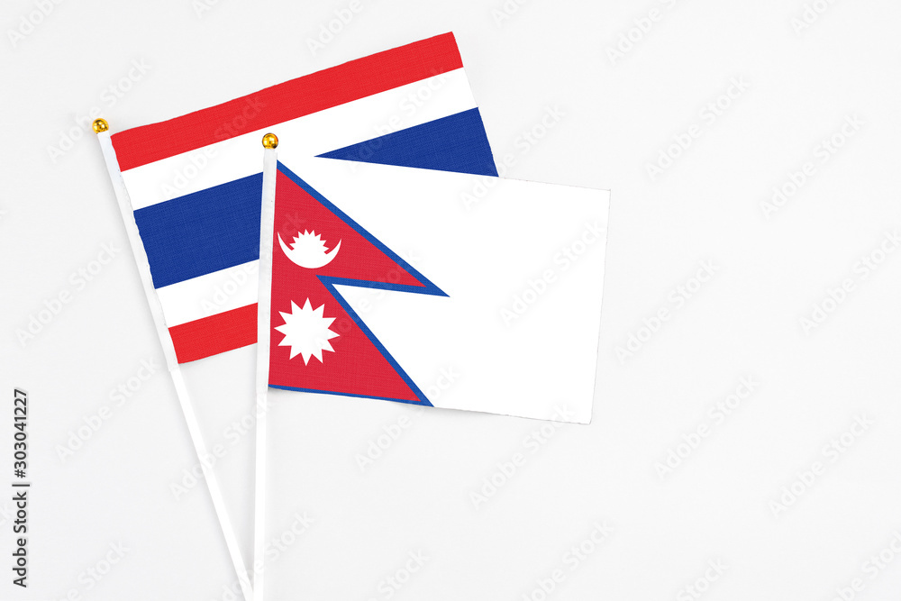 Nepal and Thailand stick flags on white background. High quality fabric, miniature national flag. Peaceful global concept.White floor for copy space.
