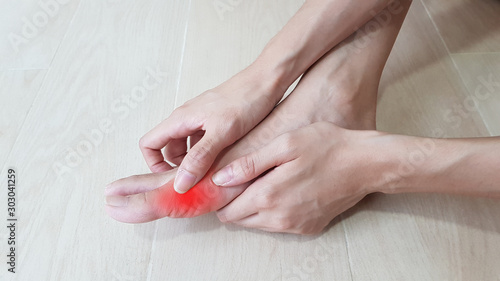 Foot anatomy with red highlight on painful area.  Toe pain may cause from bone fracture, tendinitis, ligament sprain, osteoarthritis, gouty arthritis, rheumatoid arthritis. medical symptom concept. photo