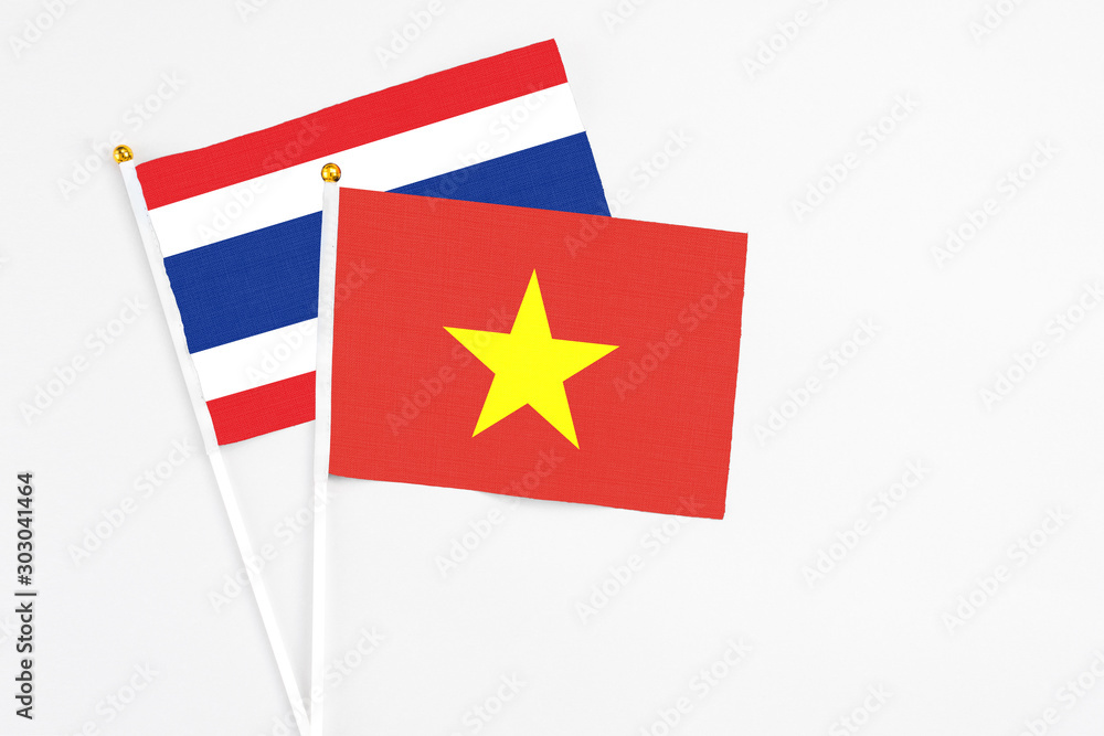 Vietnam and Thailand stick flags on white background. High quality fabric, miniature national flag. Peaceful global concept.White floor for copy space.