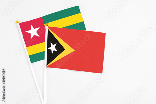 Free Download East Timor and Togo stick flags on white background. High quality fabric, miniature national flag. Peaceful global concept.White floor for copy space. - GFXLoad