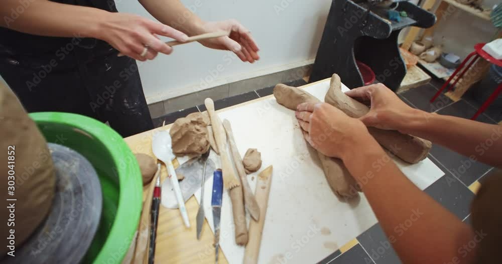 Top view of female hands modeling ceramic sculpture souvenir in craft handmade art studio. Sculptor artist teaching student. Closeup woman hands creating cley pot on pottery table. Performance inspire Top view of female hands modeling ceramic sculpture souvenir in craft handmade art studio. Sculptor artist teaching student. Closeup woman hands creating cley pot on pottery table. Performance inspire