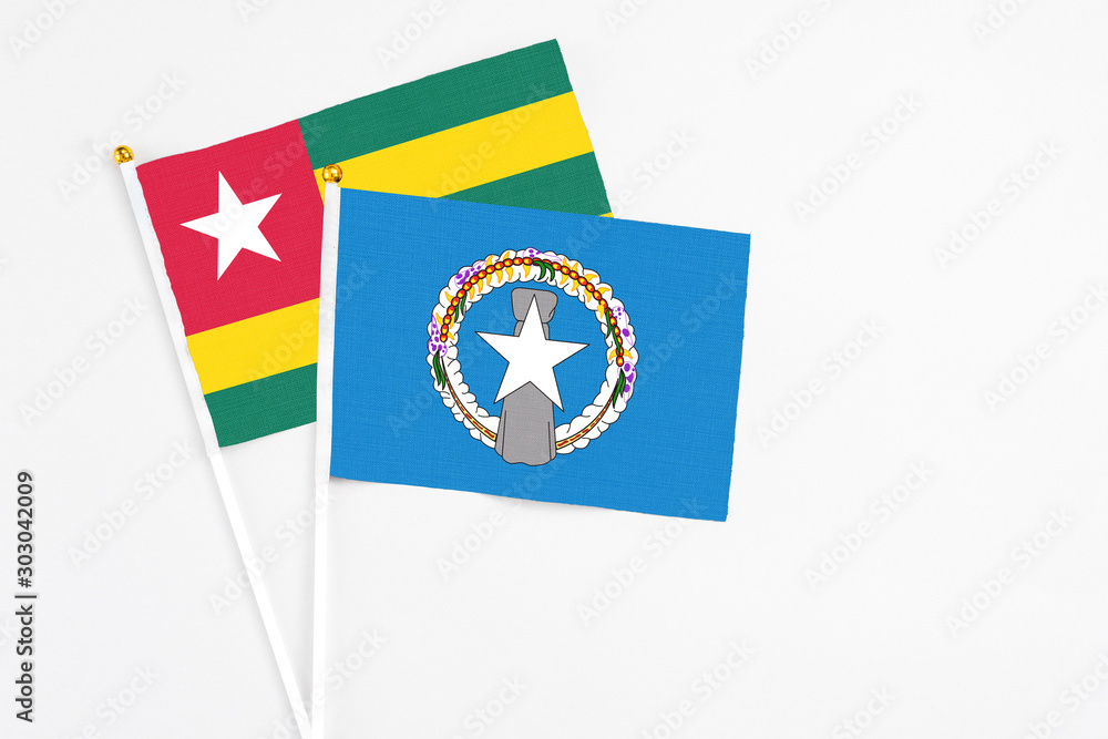 Northern Mariana Islands and Togo stick flags on white background. High quality fabric, miniature national flag. Peaceful global concept.White floor for copy space. Northern Mariana Islands and Togo stick flags on white background. High quality fabric, miniature national flag. Peaceful global concept.White floor for copy space.