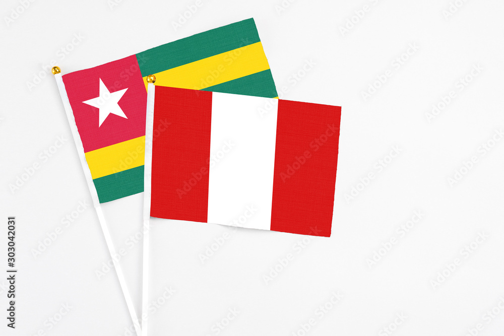 Fototapeta premium Peru and Togo stick flags on white background. High quality fabric, miniature national flag. Peaceful global concept.White floor for copy space.