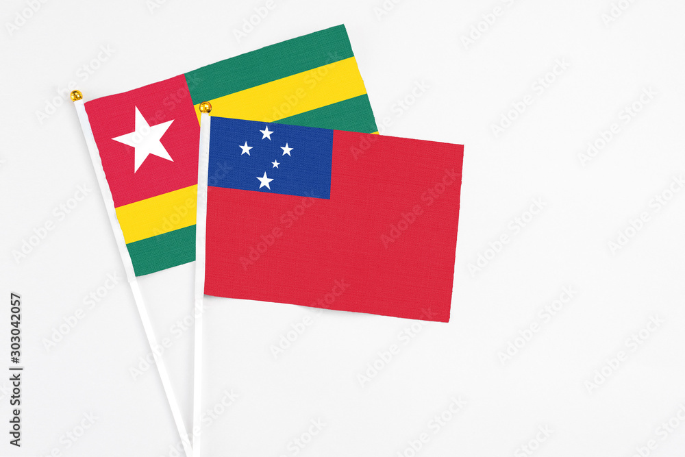 Samoa and Togo stick flags on white background. High quality fabric, miniature national flag. Peaceful global concept.White floor for copy space.