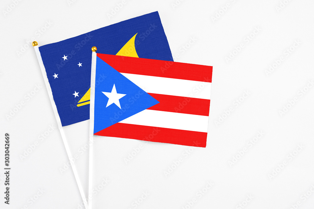 Puerto Rico and Tokelau stick flags on white background. High quality fabric, miniature national flag. Peaceful global concept.White floor for copy space.
